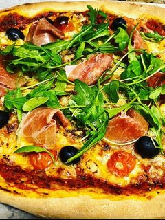 Una foto de Pizza de rúcula y prosciutto con masa madre casera