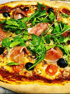 Una foto de Pizza de rúcula y prosciutto con masa madre casera