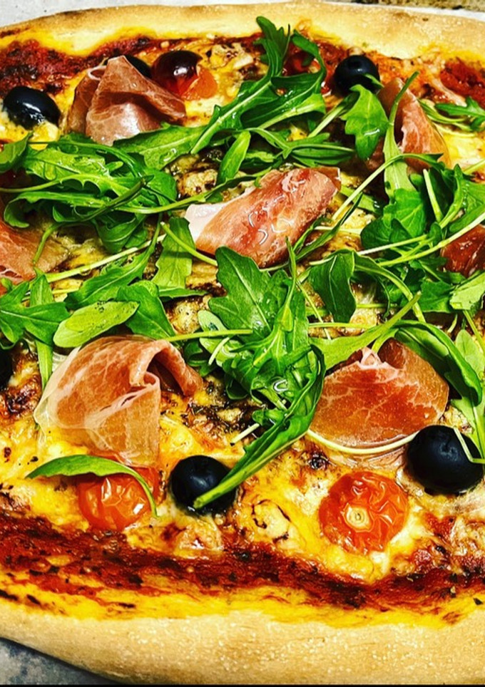Una foto de Pizza de rúcula y prosciutto con masa madre casera