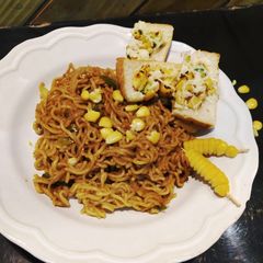 A picture of Spaghetti with marinara sauce with cheese corn toast.
