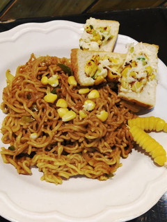 A picture of Spaghetti with marinara sauce with cheese corn toast.