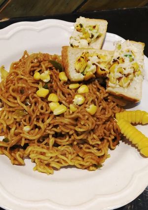 A picture of Spaghetti with marinara sauce with cheese corn toast.