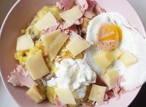 Une photo de Polenta au fromage, champignons, jambon et oeuf au plat
