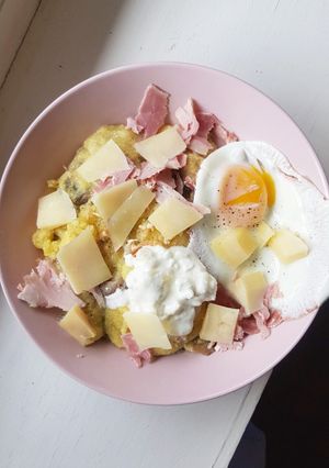 Une photo de Polenta au fromage, champignons, jambon et oeuf au plat