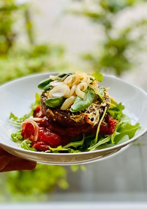 A picture of Cheesy baked mushrooms in tomato sauce.