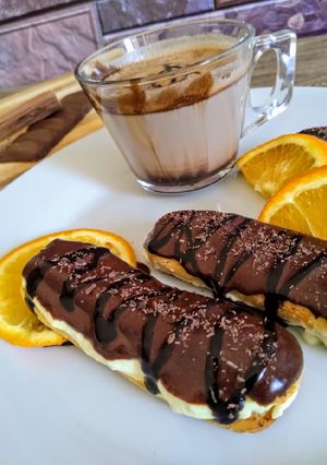 A picture of Choco orange eclair with fresh cream...cup of hot chocolate.