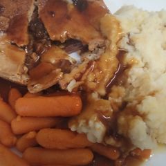 A picture of Gluten free steak pie with fluffy mash with carrots and gluten free gravy.