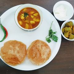 A picture of Masala kachori with aloo tamatar curry.