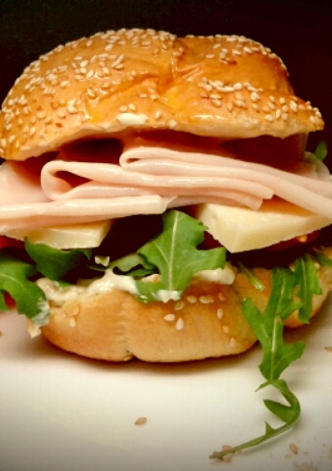 Una foto de Sándwich de Pechuga de Pavo, Queso, Rúcula, Tomate y Mayonesa de Curry.
