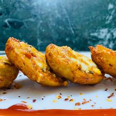 A picture of Baked potatoes marinated with yoghurt and spices.