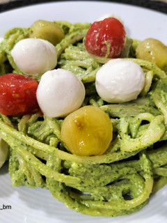 Una foto de Spaghetti al pesto de rúcula y nueces con cherrys y mozzarella