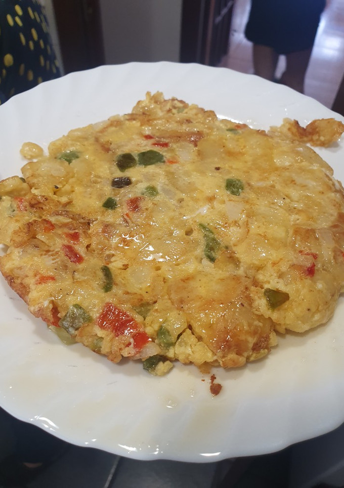 Una foto de Tortilla de patata, cebolla, pimiento rojo y verde