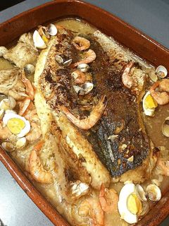 Una foto de Merluza en salsa de ajo con gambas y berberechos