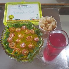 A picture of Red khandvi in yellow daal.