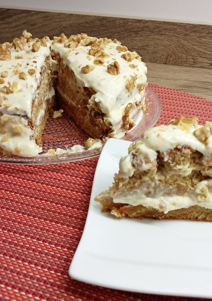 Una foto de Tarta de zanahoria cubierta de crema y nueces (carrot cake)