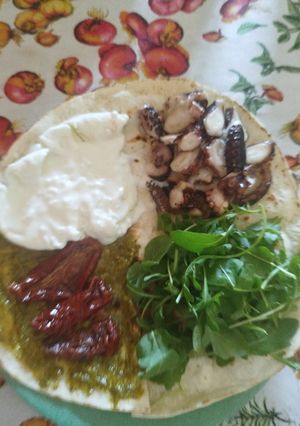 A picture of Piadina with Octopus, Burrata, Pesto, Sun-Dried Tomatoes & Arugula.