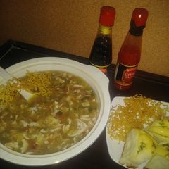 A picture of Chicken manchow soup with scallion garlic bread.