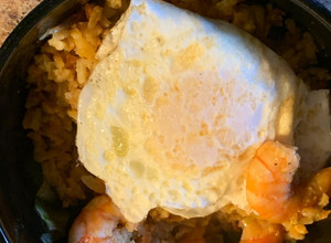 Una foto de Arroz chino con camarones y un huevo estrellado