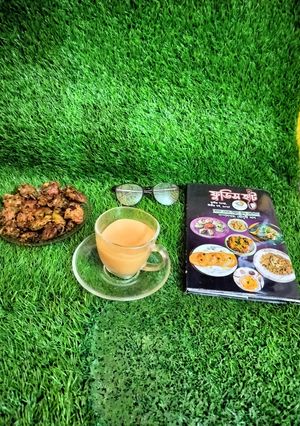 A picture of Masala milk tea with spring onion pakoda.