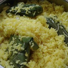 A picture of Patauri pulao (fried rice with stuffed banana leaf envelopes).