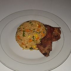 A picture of Chinese fried rice with fried chicken.