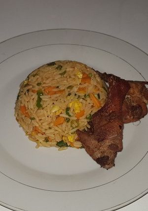 A picture of Chinese fried rice with fried chicken.