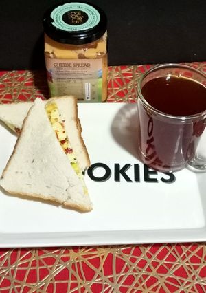 A picture of Cheesy Scrambled Egg Sandwich With Black Tea.