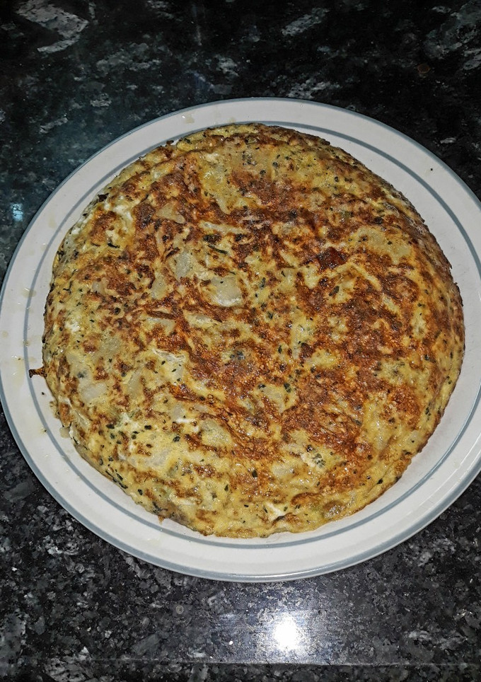 Una foto de Tortilla de patata y cebolla con adobo de ajo y perejil