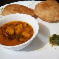A picture of BOKAKHAT POORI AALU BHAJI With Green Chilli Chutney.