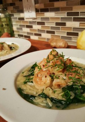A picture of Butter poached shrimp with parmasan spinach orzo risotto.