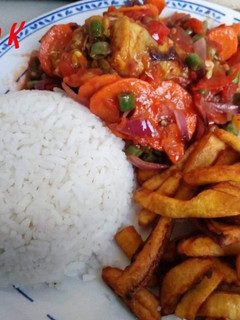 A picture of Rice with sauce and fried plantain.