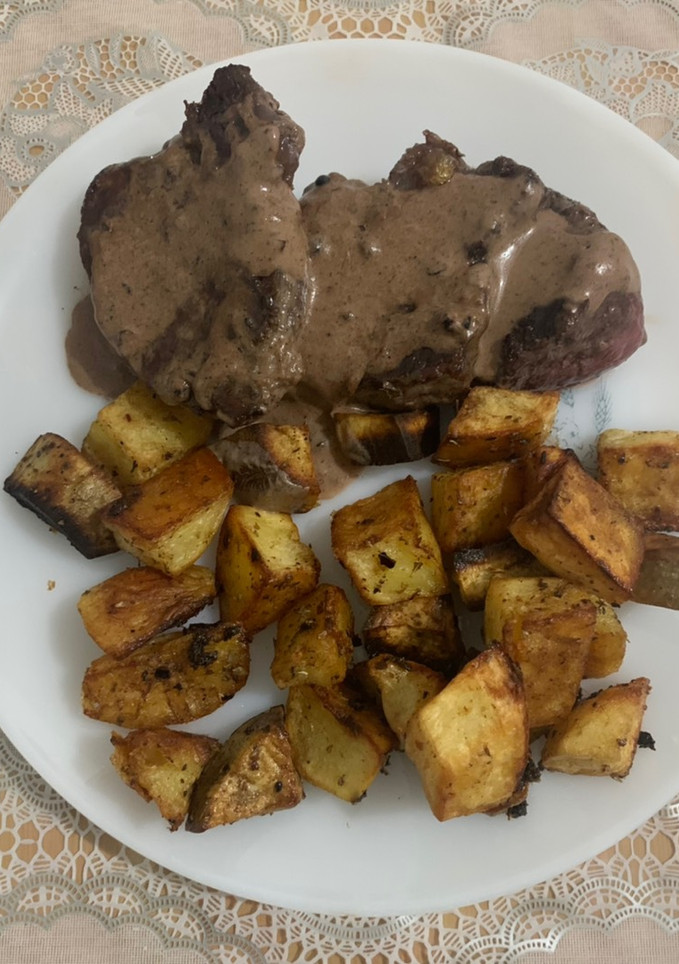 Una foto de Lomo al mix de pimienta con papas y batatas al horno