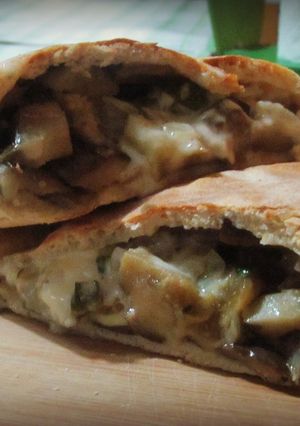 Una foto de Calzone de berenjenas, verdeo y albahaca