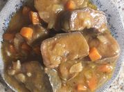 Una foto de lengua con cebollas y zanahoria