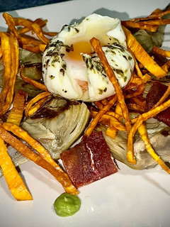 Una foto de Alcachofa con crujiente de Jamón Ibérico Huevo Poché Boniato paja y Crema de Guisantes