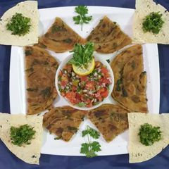 A picture of Masala paratha with salsa.