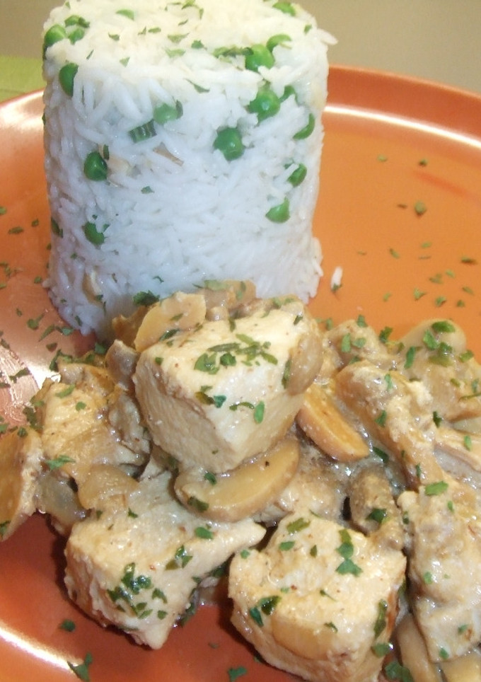Una foto de Strogonof de pollo con arroz, guisantes y nueces