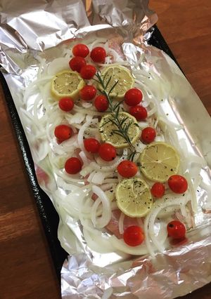 Una foto de Filet de merluza con cebolla, limón y cherry