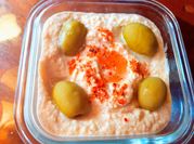Una foto de hummus aceituna