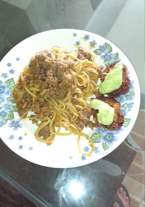Una foto de Pasta a la boloñesa con pan de ajo