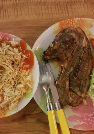 A picture of Panfried steak served with fried rice and veges.