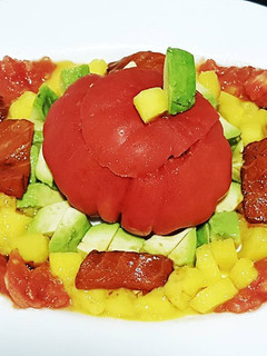Una foto de Tomate Montserrat relleno de salmón marinado, aguacate y mango