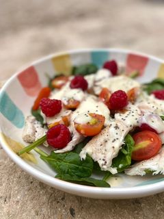 Una foto de Ensalada de espinacas con pollo, frambuesas y salsa de yogur