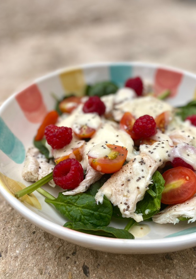 Una foto de Ensalada de espinacas con pollo, frambuesas y salsa de yogur