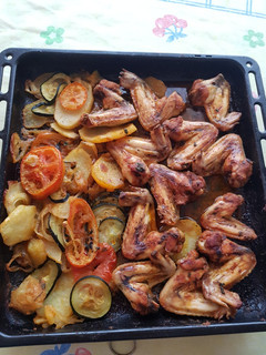 Una foto de Alitas de pollo al horno con patatas y verduras