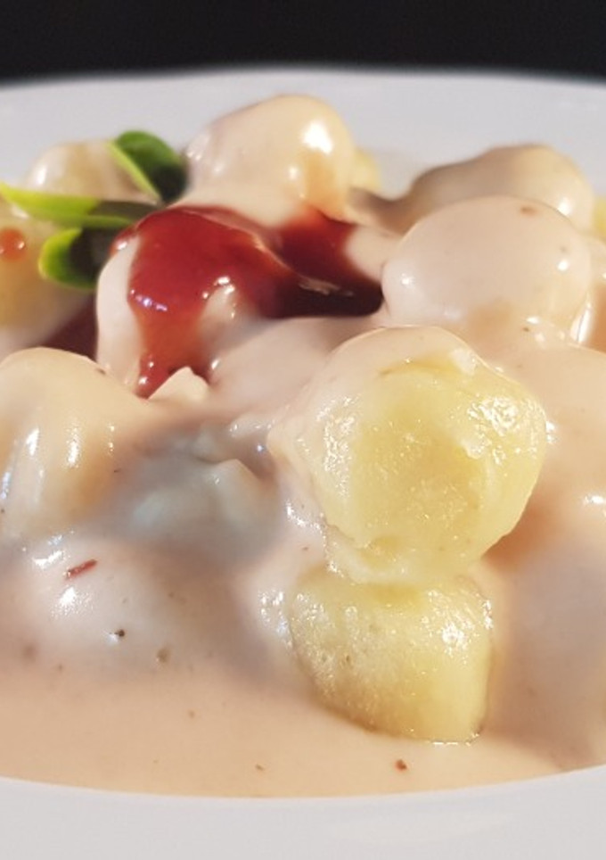 Una foto de Ñoquis con salsa de queso de cabra y mermelada de frutos del bosque