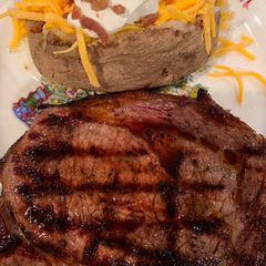 A picture of Texas Ribeye with a Baked Potato.