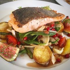 A picture of Seared salmon on figs, roasted potatoes, fennel spinach and pomegranate dressing.