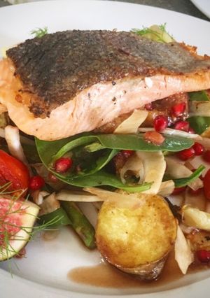 A picture of Seared salmon on figs, roasted potatoes, fennel spinach and pomegranate dressing.