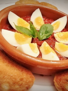 Una foto de Huevos duros con sofrito de tomate y pan frito